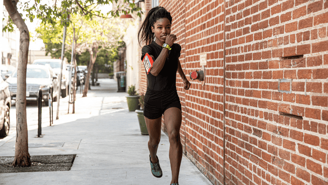 young female runner running outside on sidewalk in city - female runner bone density - bone health for runners