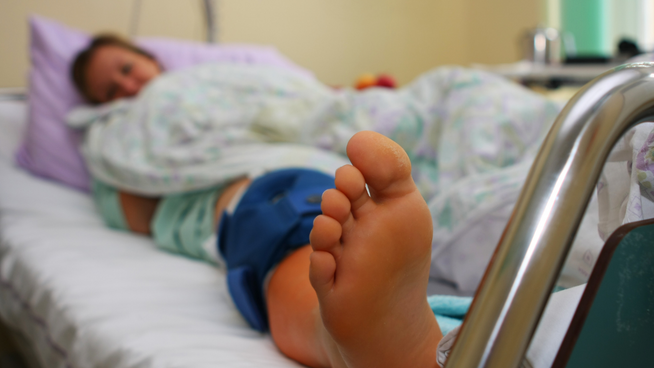 female youth athlete in hospital bed with acl injury