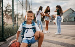 Young male with basketball outside at school